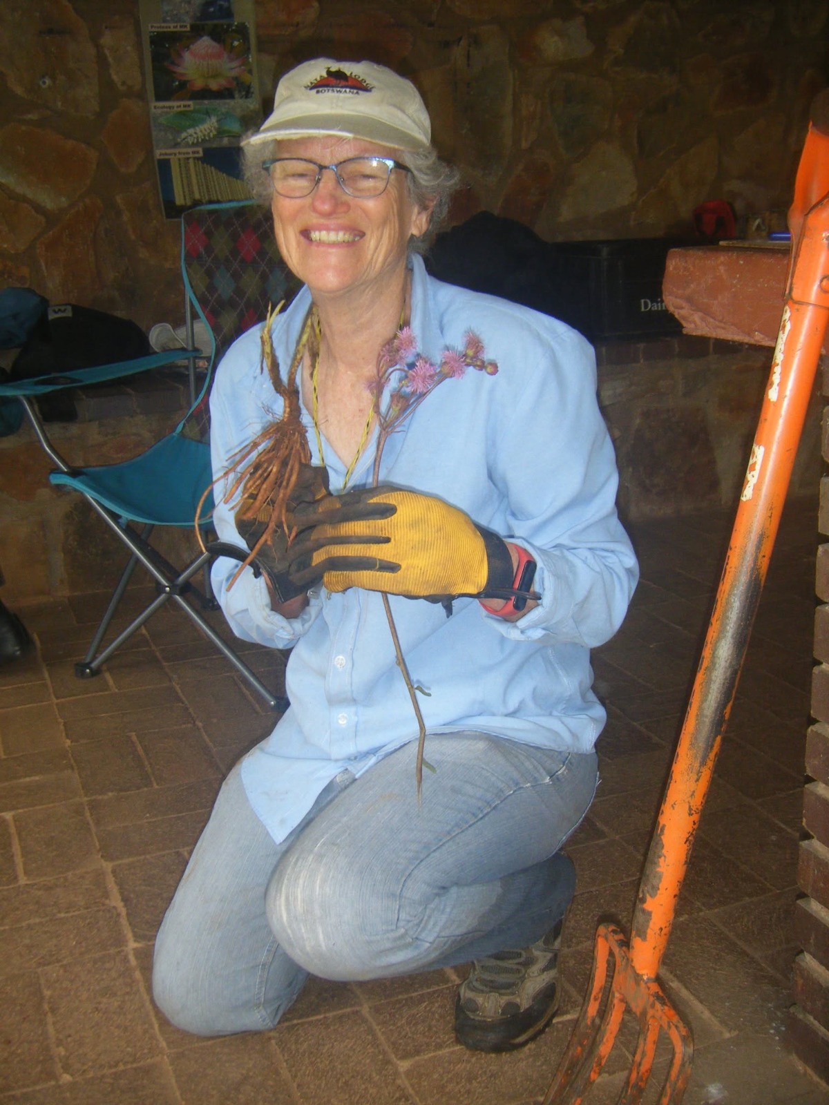 Jenny Grice holding a plant with its roots during conservation work
